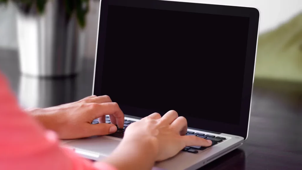 Mains utilisant un ordinateur portable sur un bureau, écran neutre