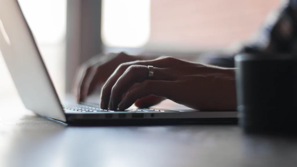 Mains sur un ordinateur portable dans un contexte de travail informatique